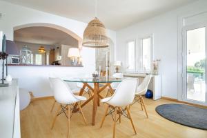a dining room with a glass table and white chairs at V022 - VILLA ELS OLIVARS in Pau