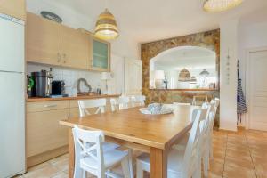 a kitchen and dining room with a wooden table and white chairs at V022 - VILLA ELS OLIVARS in Pau +37 photos