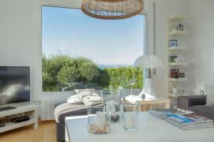 a living room with a table and a large window at V022 - VILLA ELS OLIVARS in Pau