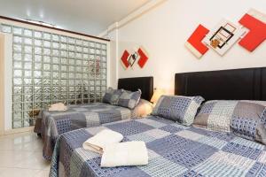 a bedroom with two beds and a large window at Ipanema avenida Vieira Souto in Rio de Janeiro