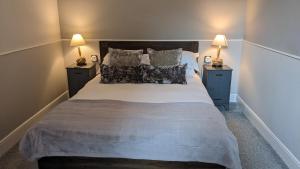 1 dormitorio con 1 cama grande y 2 mesitas de noche en Oaklands Guest House, en Weymouth