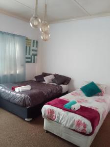 Cape Town的住宿－LRN Brackenfell Homestay，一间带两张床和一张沙发的卧室