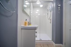baño blanco con ducha y lavamanos en Double Ensuite Bedroom near Edinburgh, en Kirkcaldy