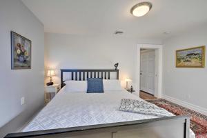 1 dormitorio con 1 cama grande con sábanas blancas y almohadas azules en Bright Apartment - half Mi to Greenport Harbor!, en Greenport