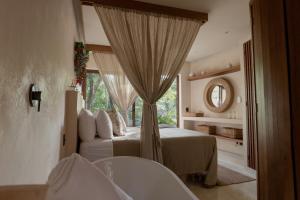 een slaapkamer met een bed, een raam en een bad bij Rubi Tulum in Tulum
