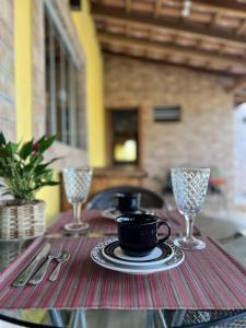 沙帕達－杜斯吉馬朗伊斯的住宿－Pousada Lótus，桌子,桌子上放着杯子,盘子和酒杯