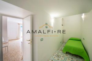 una stanza con un pouf verde in un angolo di Casa Smeraldo ad Amalfi
