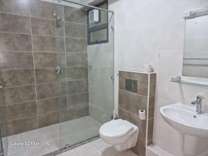 a bathroom with a shower and a toilet and a sink at Joy Pristine Nairobi in Silverstone, 2 bed&bathroom, swimming pool, free parking in Nairobi