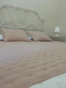 San Michele di GanzariaにあるCasa Pinùのピンクの枕と金属製のヘッドボード付きのベッド