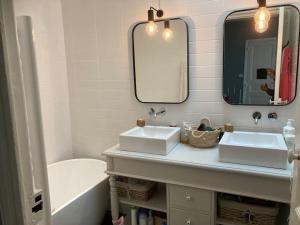 uma casa de banho com 2 lavatórios, um espelho e uma banheira em Charmante maison de ville à Salon de Provence em Salon-de-Provence