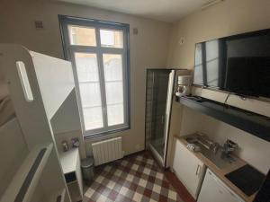 łazienka z umywalką i telewizorem na ścianie w obiekcie Mini studio centre de Rouen - 188 w Rouen
