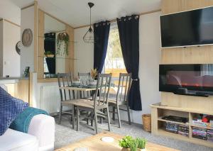 a living room with a dining room table with chairs at Treehouse - Hot Tub in Newton on the Moor