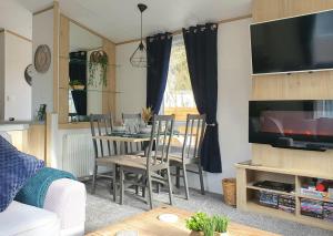 sala de estar con mesa de comedor con sillas en Treehouse - Hot Tub, en Newton on the Moor