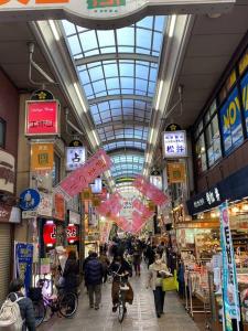 a shopping mall with people walking through a market at 天神橋筋六丁目駅徒歩2分！屋上テラス付き一軒家 天満居酒屋街2分 梅田10分 難波15分 最大13名 in Osaka
