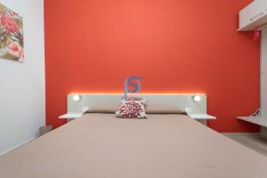 a bed in a room with a red wall at B&B Panorama - Self Check in in Cefalù
