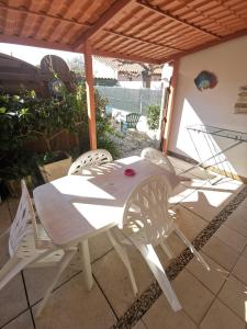 - une table et des chaises blanches sur la terrasse dans l'établissement Villa Cosy de plain pied - Marseillan, à Marseillan