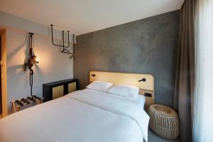 ein Schlafzimmer mit einem weißen Bett in einem Zimmer in der Unterkunft ibis Styles Bayreuth in Bayreuth
