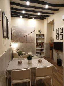 Apartament Imperial WI FI center Seville في إشبيلية: غرفة معيشة مع طاولة وكراسي وأريكة