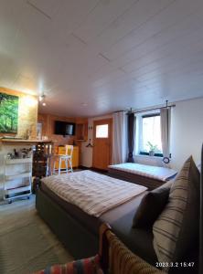 a bedroom with two beds and a couch and a kitchen at Ferienwohnung Schug in Homburg