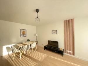 jadalnia ze stołem, krzesłami i telewizorem w obiekcie Bel appartement pour 6 avec parking - Rive gauche - 183 w Rouen