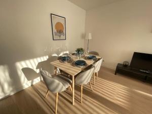 a dining table and chairs in a living room at Bel appartement pour 6 avec parking - Rive gauche - 183 in Rouen
