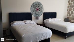 um quarto com duas camas e um relógio na parede em Departamento Mamá Rosario em Morelia