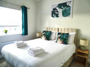 a bedroom with a large white bed with towels on it at Tolcarne - Perranporth Cornwall in Perranporth