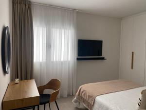 een hotelkamer met een bed, een bureau en een televisie bij Castelar Rooms in Las Palmas de Gran Canaria