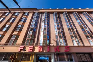 a large building with a pink sign on it at Feniks Fragola Apartments in Krakow