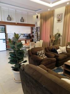 a living room with two couches and a kitchen at شالية قاردن لايت in Taif