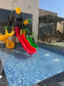 um parque aquático com escorrega numa piscina em شالية قاردن لايت em Taif