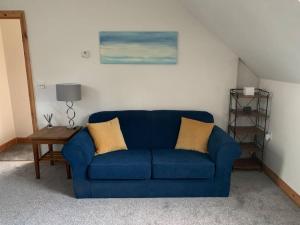 a blue couch in a living room with a table at The Apartment in Langley Park