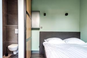 1 dormitorio con cama y aseo en Zandvoort Lodge, en Zandvoort