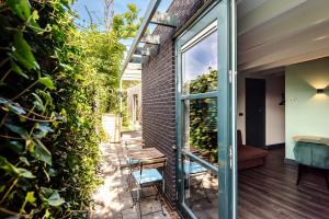 Habitación con jardín, pared verde y puerta de cristal en Zandvoort Lodge, en Zandvoort