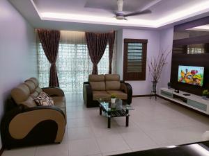 a living room with two couches and a tv at Sekinchan Paddy via Seaview Home in Sekincan