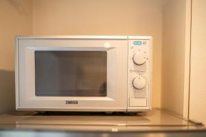 a microwave oven sitting on top of a counter at Andrea Apartment in Liepāja