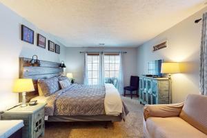um quarto com uma cama e um sofá em Fall Creek Resort Pond View Escape em Branson