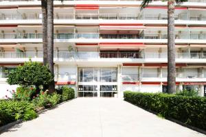 una vista esterna di un edificio con palme di Studio au bord de mer 1 a Mentone