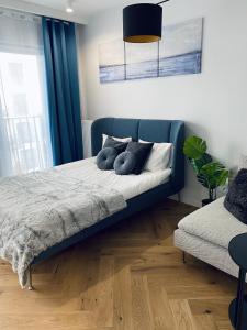 - une chambre avec un lit bleu et une fenêtre dans l'établissement Wileńska home apartment 2, à Varsovie