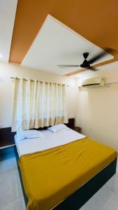 um quarto com uma cama amarela e uma ventoinha de tecto em Devka House em Damão
