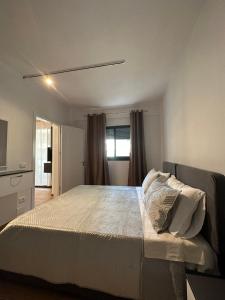 um quarto com uma cama grande e uma janela em Bonaparte apartments em Vlorë