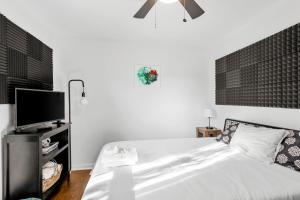 a bedroom with a bed and a flat screen tv at Inglewood Rose in Nashville