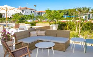 une terrasse avec un canapé, des tables et des chaises dans l'établissement International Hotel, à Cavallino-Treporti