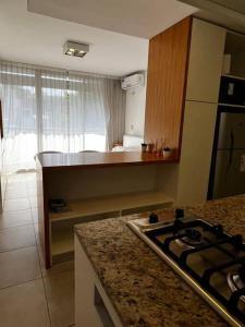 Mono frente al sanatorio de la mujer في روزاريو: مطبخ مع موقد وطاولة عمل