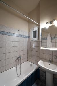a bathroom with a bath tub and a sink at Hotel Ntinas in Tríkala