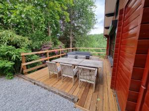a wooden deck with a table and chairs on it at Chalet Coo in Stavelot