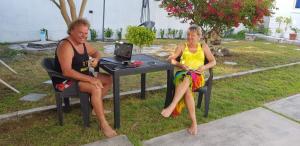 dos mujeres sentadas en una mesa con un portátil en Clove Beach, en Addu Atoll