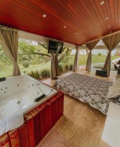 Giường trong phòng chung tại Loft Vidro Garden em Condomínio Rota do Vinho São Roque