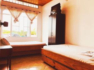 1 dormitorio con 2 camas y ventana en Acogedora casa condominio con piscina en Girardot, en Girardot