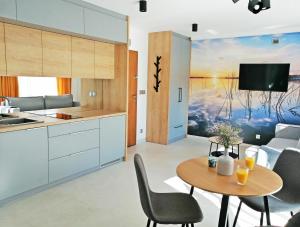 a kitchen and living room with a table and chairs at Apartamenty Na Skarpie in Ełk
